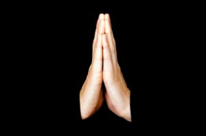 White hands at prayer.