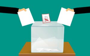 An illustration of votes being placed in a ballot box.